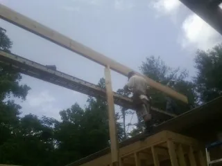 Carpenter setting a ridge beam over a new addition frame — Ice Dam Removal by Roofing Brothers in Metaline