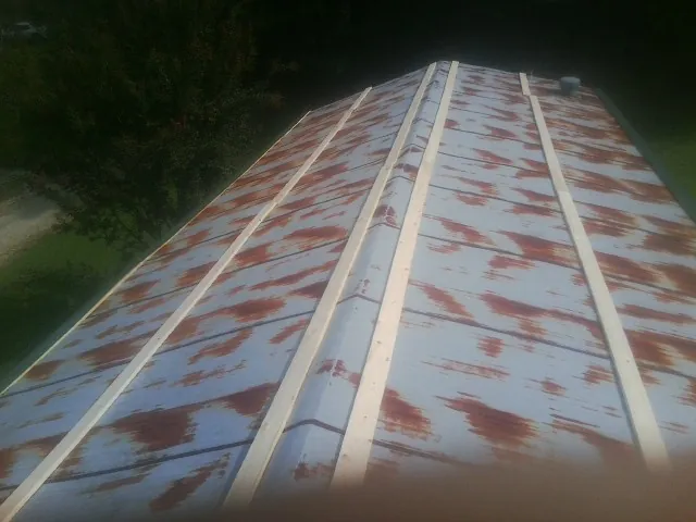 Rusted metal roof panels with new wood purlins before replacement — Storm Damage Roof Repair in Metaline by Roofing Brothers