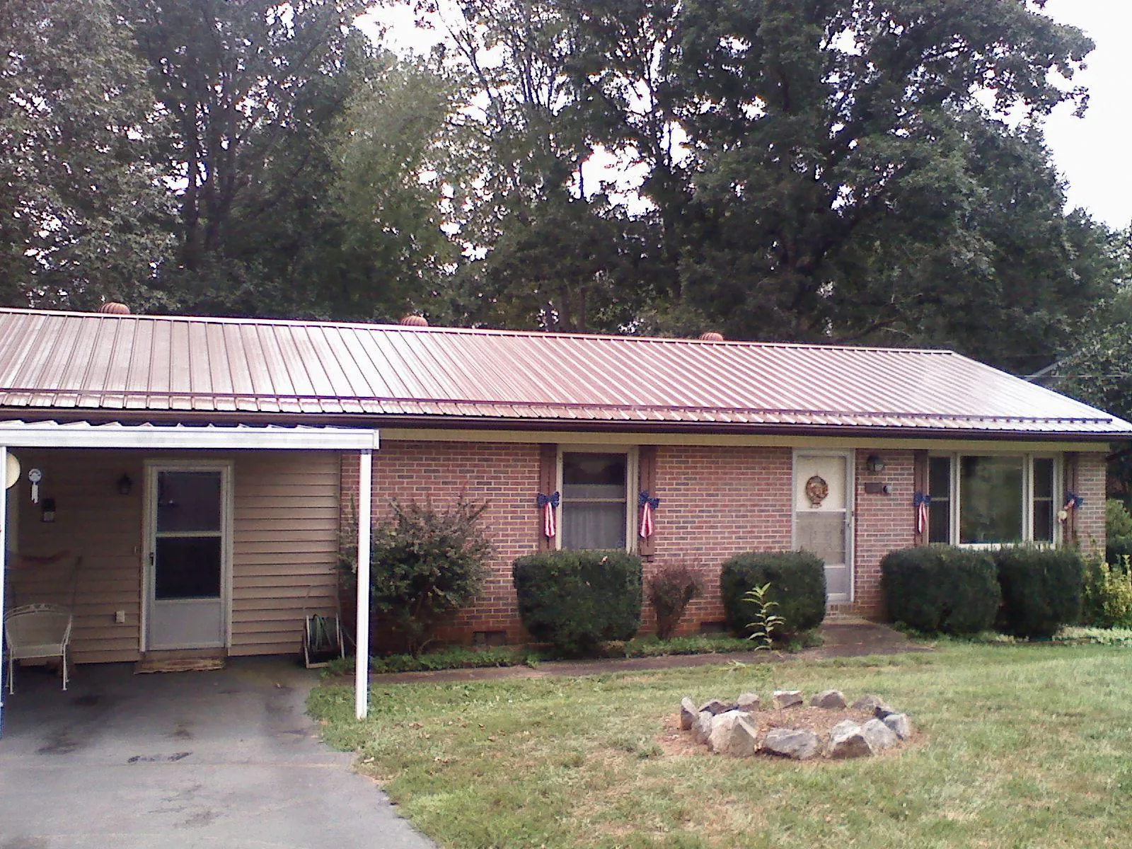 Bronze metal roof and carport on a brick ranch home — Roof Repair work by our crew in Metaline