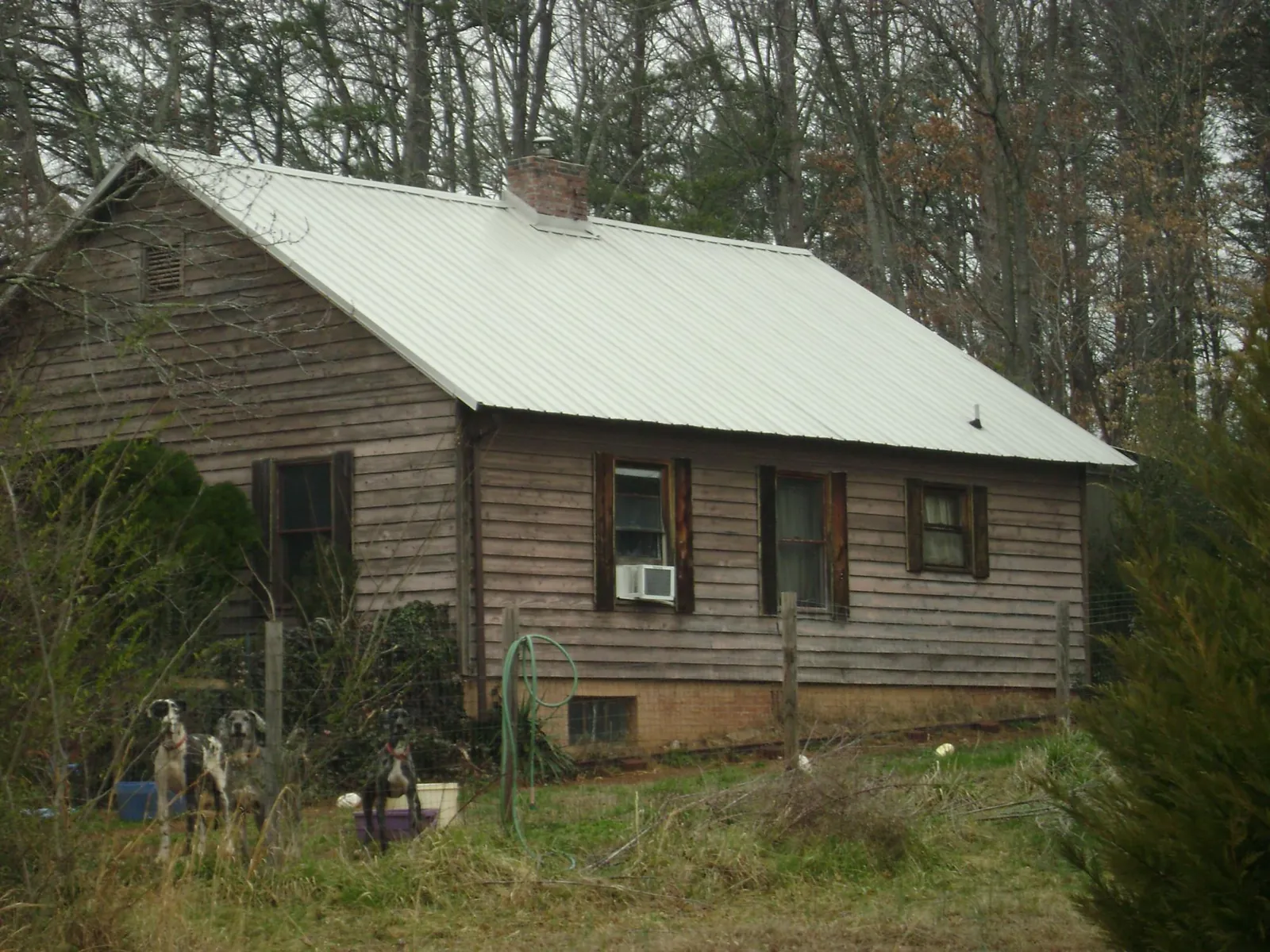 White metal roof on an old wood sided farmhouse, from a Metal Roof Installation job in Metaline
